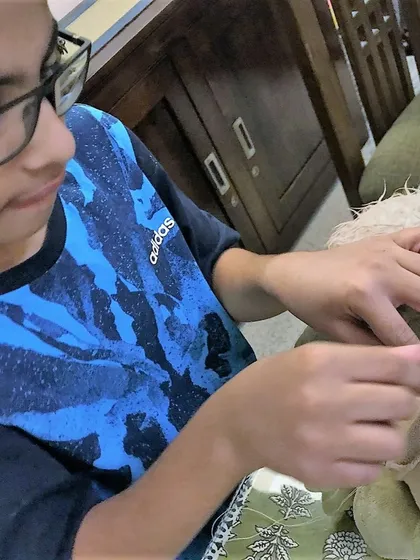 It is not just about fixing, it is about caring for the things we love. This young participant is carefully learning hand sewing techniques to mend his favorite stuffed toy, a skill that teaches patience and the value of preservation.