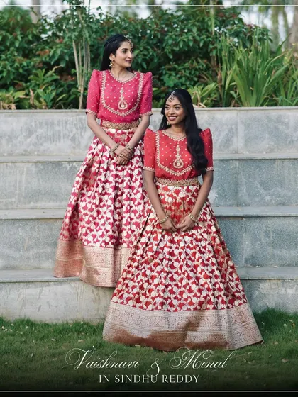 Our clients Vaishnavi and Minal look stunning in their coordinated red and pink lehengas, a perfect example of friendship goals.
