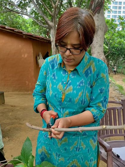 A participant carefully makes a stem cutting from a native shrub, learning another important propagation technique.