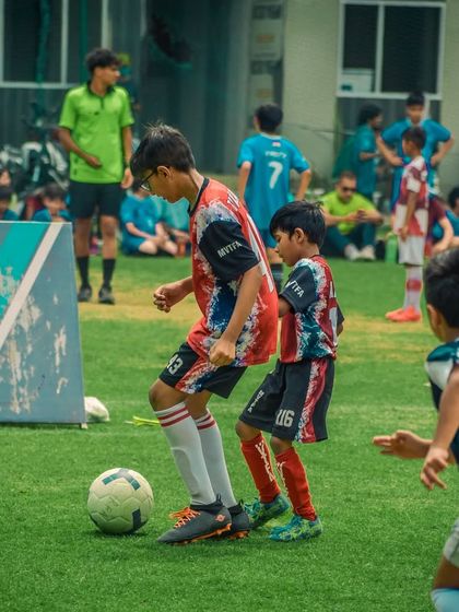 Two players from opposing teams challenge for the ball in a fair but competitive tackle.