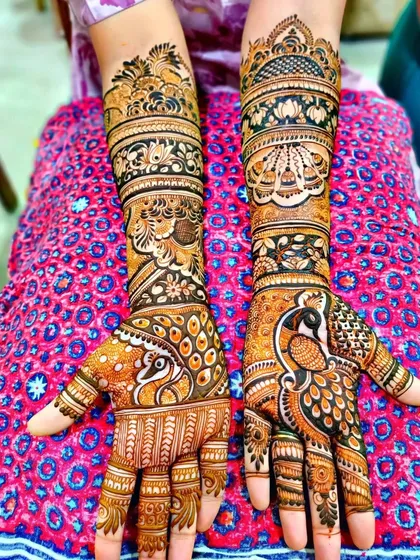 This design showcases a large, detailed peacock on the palm, with its feathers flowing down the fingers.
