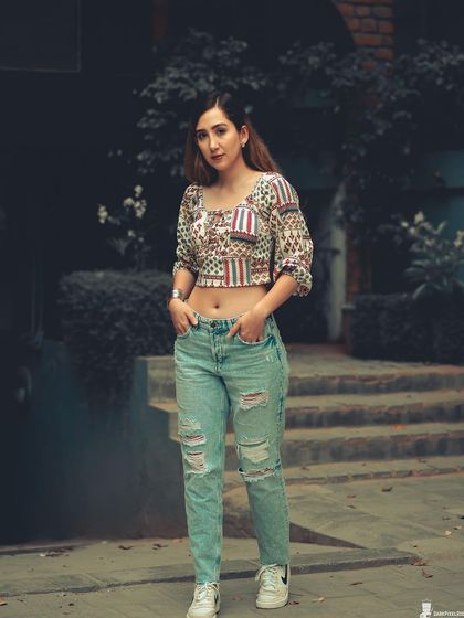 A full-body street style shot that showcases attitude and fashion. The cool-toned color grading and urban setting create a modern, grunge-inspired look.