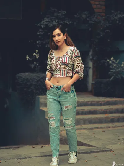 A full-body street style shot that showcases attitude and fashion. The cool-toned color grading and urban setting create a modern, grunge-inspired look.