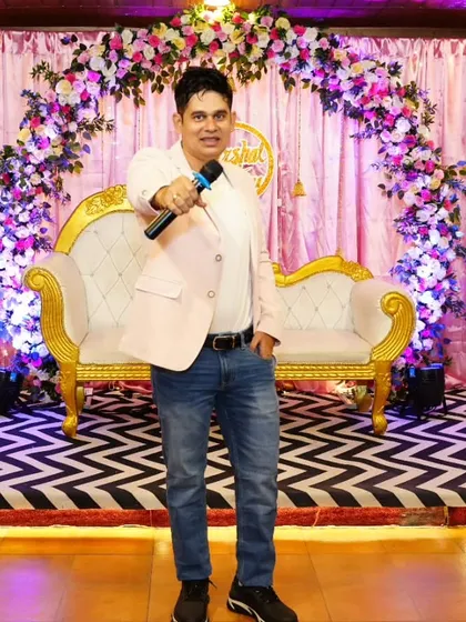 A confident pose on a beautifully decorated stage. I am always ready to bring my A-game to make your wedding event unforgettable.
