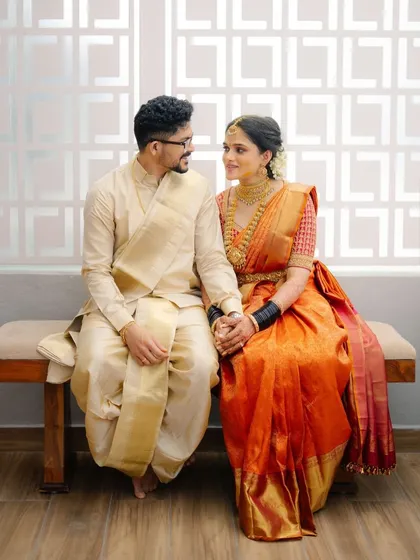 It is a joy to see my creations as part of a couple's story. Our bride Archana looks radiant in a traditional orange Kanjeevaram saree, complete with a custom hand-embroidered blouse for her wedding day.