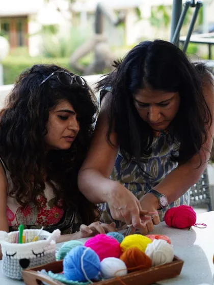 I always make sure to give one-on-one help during my workshops. Here I am guiding a student through a tricky part, surrounded by colorful yarn.