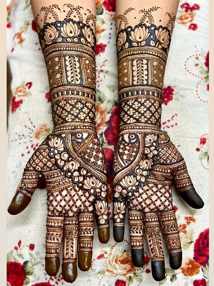 A beautiful full-hand design with a focus on lotus and peacock motifs. The intricate check patterns and floral details create a very rich look.