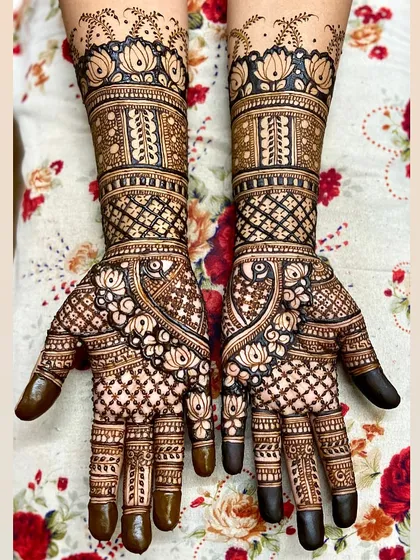A beautiful full-hand design with a focus on lotus and peacock motifs. The intricate check patterns and floral details create a very rich look.