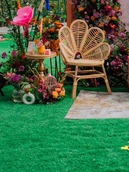 This special peacock-style wicker chair is reserved for the bride, creating a beautiful and distinct seat of honor amidst the lush floral decor.