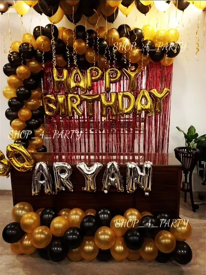 A classic and bold black and gold birthday theme. This setup includes a balloon arch over a red shimmer curtain, with the name spelled out in silver foil letters for a personalized touch.