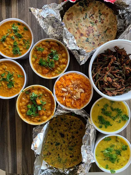 A comforting home cooked meal prepared for a client's son studying abroad. This includes Methi Theplas, Dal Tadka, Masala Chole, and Gajar ka Halwa, all ready for dehydration.