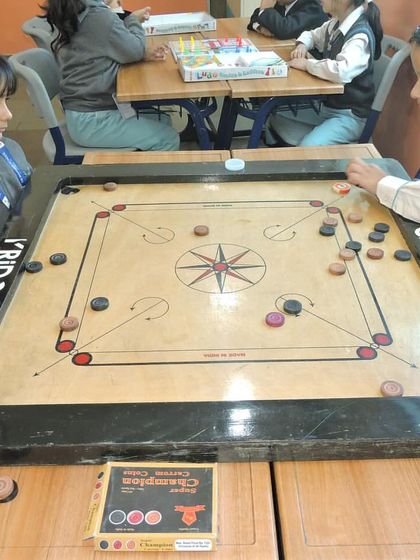 During Device Detox Day, students engage in classic board games like Carrom, fostering social interaction and strategic thinking.