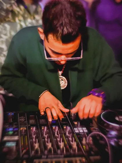 A close up shot of my hands on the mixer at Mandem Club. This shows the technical side of my work, carefully blending beats and adjusting levels to create the perfect sound.