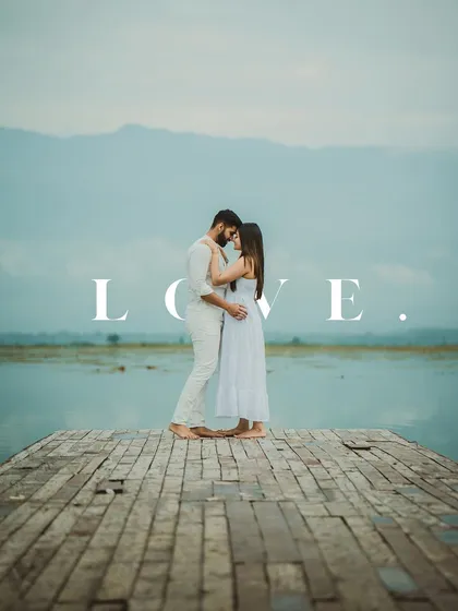 A romantic full-length shot of a couple embracing on a wooden pier, with the word "LOVE" overlaid.