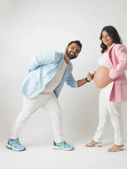A fun and dynamic pose with the dad to be playfully pointing at the baby bump. The colorful blazers add a pop of personality to this modern couple's maternity shoot.