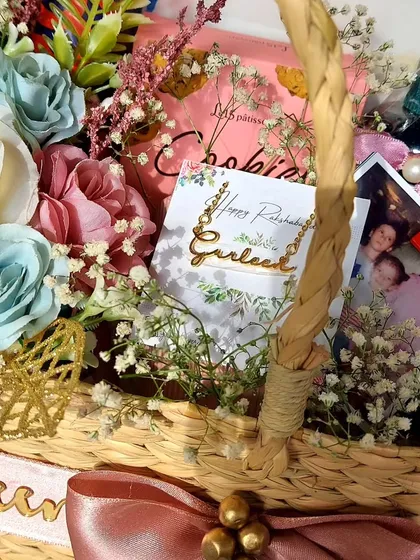 A close-up of our personalized gift basket for a sister on Rakhi. It features a custom name necklace, a childhood photo, and other handpicked items to make it truly special.