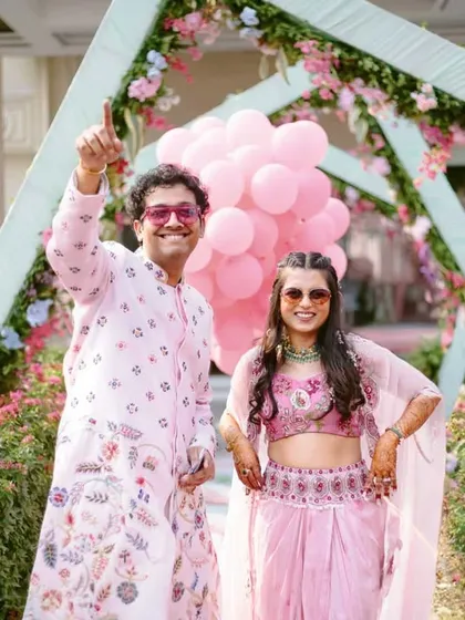 A fun and energetic entrance by the couple at their carnival-themed event, complete with pink balloons and cool sunglasses.