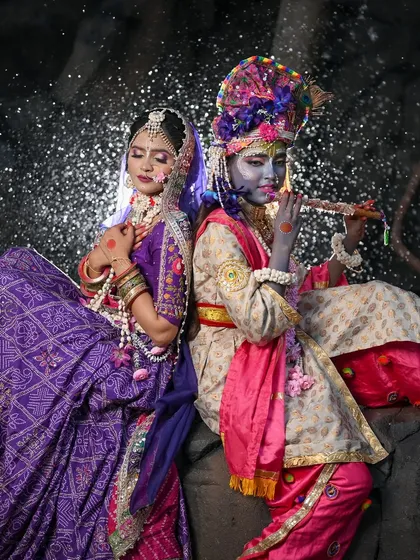 A dramatic shot of Radha and Krishna with a sparkling background.