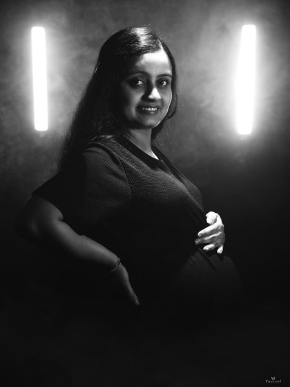 A creative black and white portrait using tube lights for a modern, edgy feel. The smoky atmosphere adds to the dramatic effect of this unique maternity photo.
