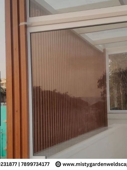 A view of the WPC louvers from the side, showing how they create a solid privacy screen that complements the modern aesthetic of the glass and metal structure.