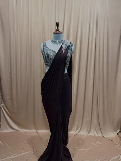 A deep wine-colored drape saree paired with a contrasting silver embroidered blouse. A rich and luxurious combination for any festive occasion.