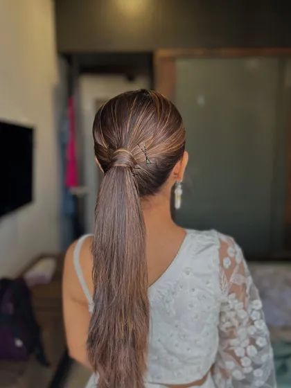 A sleek and modern high ponytail is a fantastic choice for a contemporary look. This style is clean, polished, and keeps the focus on the client's face and outfit, making it perfect for a stylish party or formal event.