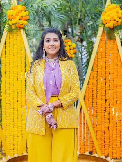 The bride's modern and chic Haldi outfit. The makeup is kept fresh and minimal to complement the stylish yellow and lavender co-ord set.