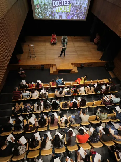 An overhead view of the "La Dictée pour Tous" event in our auditorium, showing the scale and engagement of the participants.