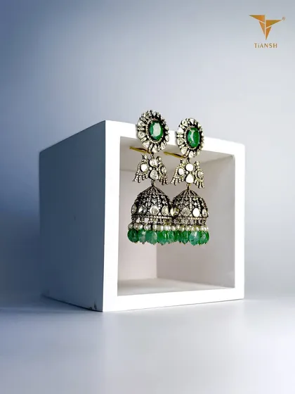 These traditional kundan jhumkas are handcrafted with uncut diamonds and emeralds, where timeless design meets precision craftsmanship.