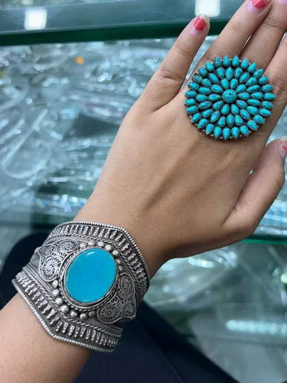 A bold and beautiful look. This image shows a large turquoise statement ring paired with a wide, oxidised silver cuff with a large turquoise stone.