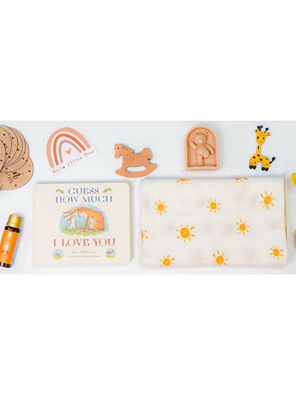 A wide banner-style flatlay of baby gift items. This kind of 'knolling' photography is perfect for website headers or promotional banners, showing a wide range of products at once.