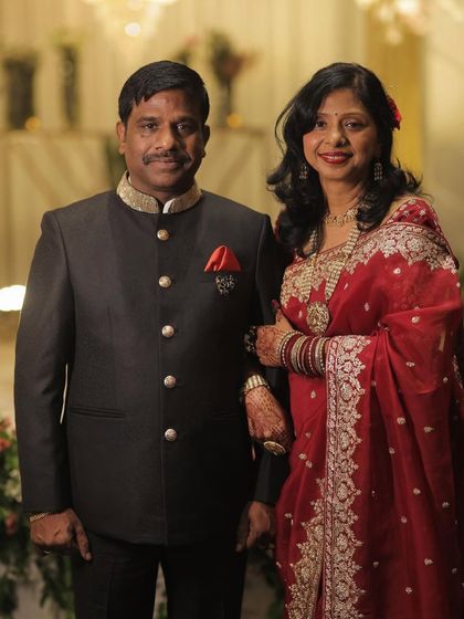 Mr. and Mrs. Jain at their daughter's wedding. His bespoke bandhgala ensures he looks his absolute best for this momentous family occasion.