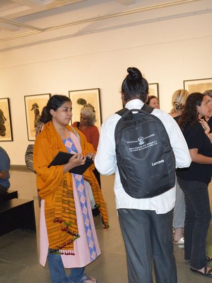 A group of visitors listening to a friend explain a piece.
