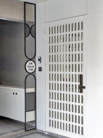 The entrance features a custom metal nameplate and a perforated security door, showcasing attention to detail from the very first impression.