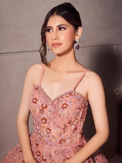 A full view of the embroidered pink gown. The makeup is glamorous yet sweet, a perfect match for a cocktail or reception event.