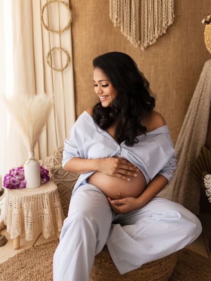 A beautiful solo portrait, with the mother-to-be cradling her bump in our cozy boho corner.