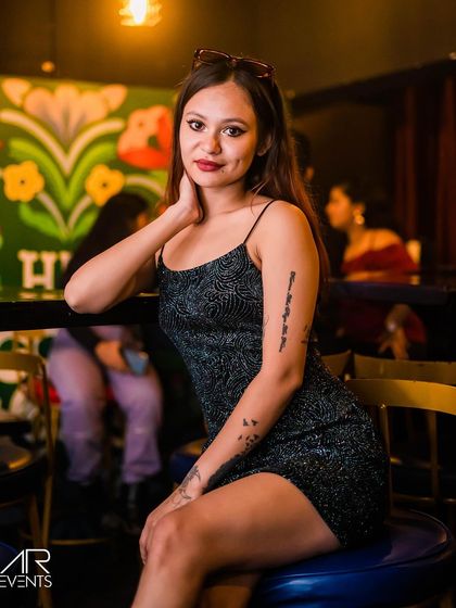 A guest posing by the colorful graffiti wall.