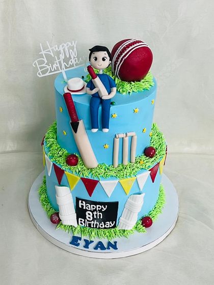 A grand two-tier cricket cake for Eyan's 8th birthday. This cake has it all: a custom player figurine, bats, balls, wickets, and pads, all handcrafted from fondant.