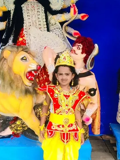 Another angle of the vibrant red and yellow mythological costume, showing how it stands out against the backdrop of the Durga Puja pandal.