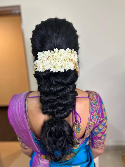 For this Varpooja look, I created a full messy braid and topped it with a traditional jasmine gajra, a timeless choice for any sacred ceremony.