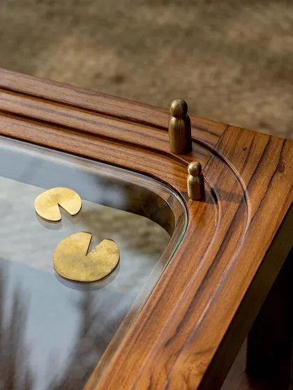 Different views of the Kulam collection, including the side table and center table. These images showcase the blend of solid teak, glass, and narrative brass accents that define this collection.