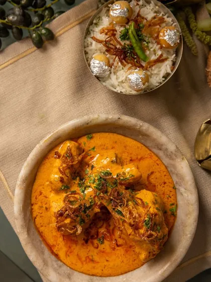 A rich and creamy chicken curry served alongside our special biryani, a classic pairing from our 'RUMI' festive collection.