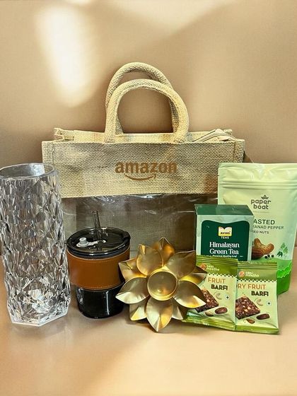 This festive gift set was created for Amazon, presented in a branded eco-friendly jute bag. It includes a mix of treats, a decorative diya, and useful items like a tumbler and vase.