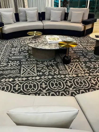 This living area is defined by its unique circular layout, featuring two curved sofas facing each other over a striking patterned rug. This arrangement fosters connection and conversation, making it a perfect setup for families who love to entertain.