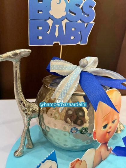 A unique Boss Baby hamper design featuring a decorative silver pot with a giraffe handle.