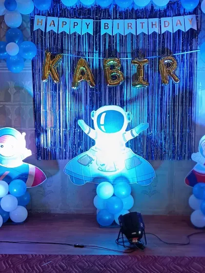 A focused shot of the astronaut cutouts against the shimmering blue backdrop. These elements are key to making the space theme feel adventurous and fun for the kids.