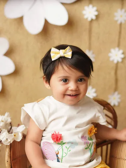 A close-up of the smiling baby girl, her cute striped bow matching her shorts. These coordinated details make the photos extra special.