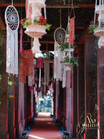 A dreamy entrance walkway lined with hanging dreamcatchers and macrame planters filled with flowers.