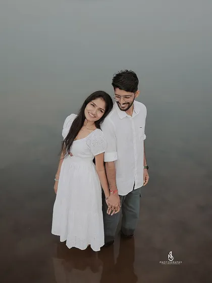 A high-angle shot looking down at the couple in the water, offering a unique and intimate perspective.