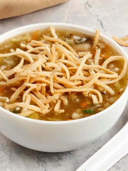 A comforting bowl of our hot and sour Manchow Soup. It's filled with finely chopped vegetables and topped with a generous handful of crispy fried noodles for that essential crunch.